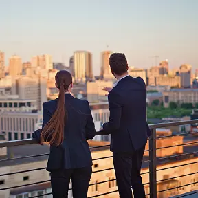 two business people looking over a balcony