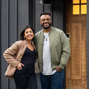 a couple infront of a house